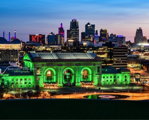 Photo by People of Cowtown showing Union Station lit green and the Kansas City skyline behind it.