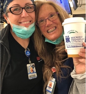Photo of two female hospital staff members hold a coffee cup with an MTN coffee sleeve.