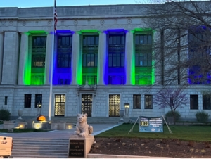 Photo of the Kansas City Life Insurance building lit up blue and green.