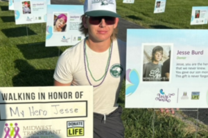 Tyler Barker, Liver Recipient with a picture from Legacy Walk with his Donor Hero Jesse Burd. 