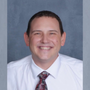 Joe Hecht, donor hero, wearing a white button-down shirt with a grey and maroon tie.